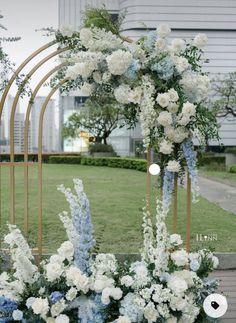 an arch decorated with white and blue flowers