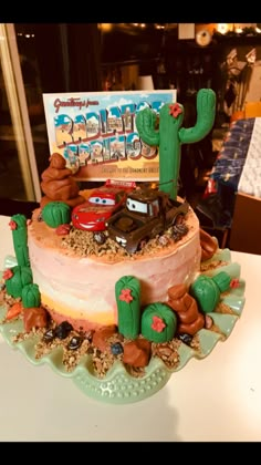 a birthday cake with cars and cactus on top