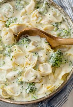 a skillet filled with tortelli alfredo and broccoli