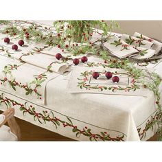 the table is covered with red berries and greenery, along with white linens