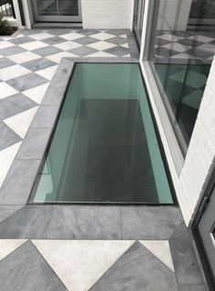 a glass window on the side of a building in front of a checkered floor