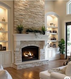 a living room filled with furniture and a fire place in the middle of a wooden floor