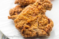 two pieces of fried chicken on a white plate