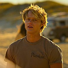 a young man standing in front of a truck