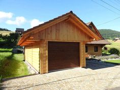 a small wooden house with a large garage