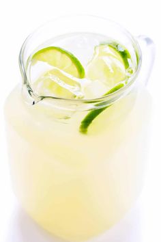 a pitcher filled with lemonade and lime slices