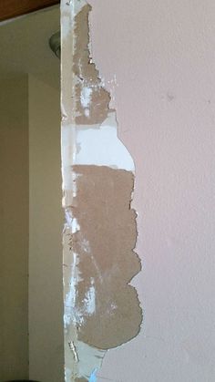 a wall that has been painted pink and white with some paint chipping off it