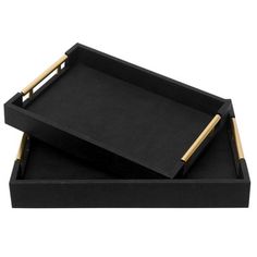 two black trays with gold handles on each side and one holding a wooden handle