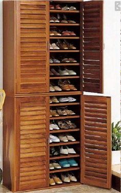 an open closet with wooden shutters and shoes