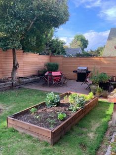 a backyard garden with raised beds and seating area