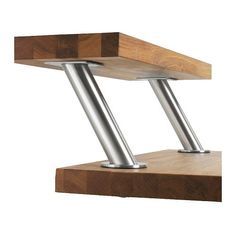 a wooden shelf with two metal legs on it's sides and a white wall in the background