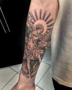 a man's arm with an angel and sun tattoo on it