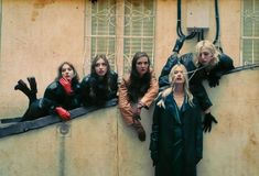 four women standing on the side of a building