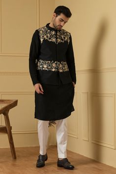 Black semi raw silk bundi with mandarin collar, floral jaal pattern peach threads and silver zari hand embroidery. Paired with full sleeves kurta and contrast trousers.
Components: 3
Pattern: Hand Embroidered
Type Of Work: Resham and Sequin Work
Neckline: Mandarin Collar
Sleeve Type: Bundi: Sleeveless, Kurta: Full Sleeves
Fabric: Semi Raw Silk
Color: Black
Other Details: 
Placement embroidery
Bundi Closure: Front concealed placket
Occasion: Sangeet,Reception - Aza Fashions Types Of Silk Fabric, Sleeveless Kurta, Placement Embroidery, Men's Ethnic Wear, Diwali Sale, Nehru Jacket, Nehru Jackets, Zari Work, Fashion App