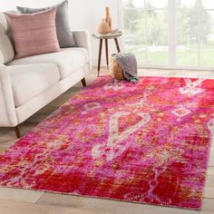 a living room with a white couch and pink rug