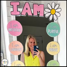 a woman taking a selfie in front of a mirror with i am signs on it