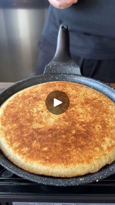 a pancake being cooked on top of a stove with a video player in the background