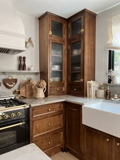 a kitchen with wooden cabinets and marble counter tops, along with a stove top oven