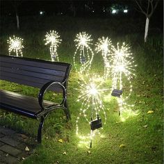 a bench sitting in the grass next to some fireworks