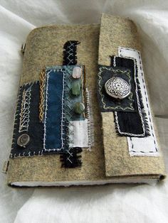 an open book covered in fabric and buttons