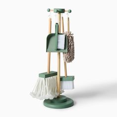 a broom, brush and dustpan on a green stand with two white mop's