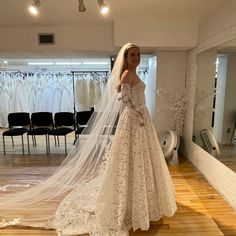 a woman standing in front of a wedding dress