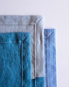 three pieces of blue and grey fabric on a white surface