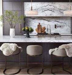 a kitchen with marble counter tops and chairs