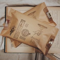 an open book with drawings on it next to some other books and paper items that are laying on top of each other