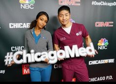 a man and woman standing in front of a chicago med sign