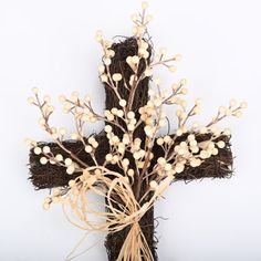 a cross made out of branches with white flowers