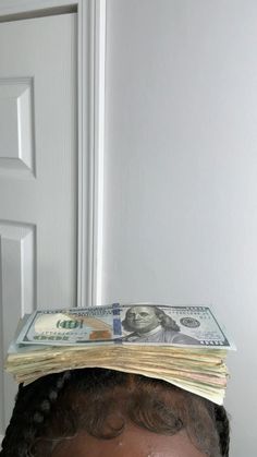 a woman with money on her head in front of a door