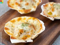 three small shells with cheese and herbs on them