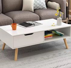 a living room with a couch, coffee table and bookshelf on the floor