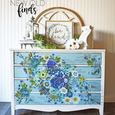 an old dresser painted with blue and green flowers