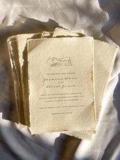 three pieces of paper sitting on top of a white cloth covered tablecloth with an image of a house