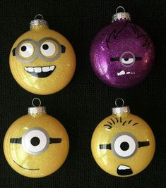 three yellow and purple christmas ornaments with eyes on each ornament, one in the shape of a minion