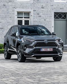 the new toyota rav is parked in front of a brick building with two windows