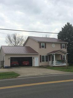 a two story house with a car parked in the driveway