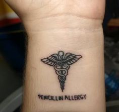 a wrist tattoo with a medical symbol on it