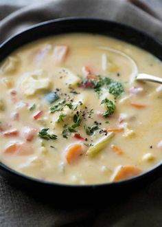 a close up of a bowl of soup with broccoli and carrots in it