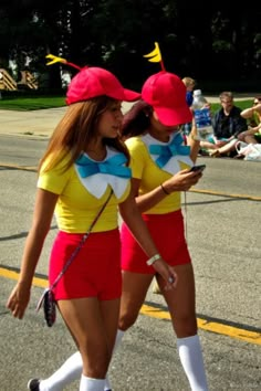 two women in matching outfits walking down the street