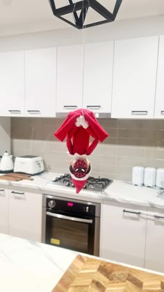 an elf hat hanging from the ceiling in a kitchen