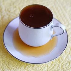 a cup of coffee sitting on top of a white saucer with liquid in it