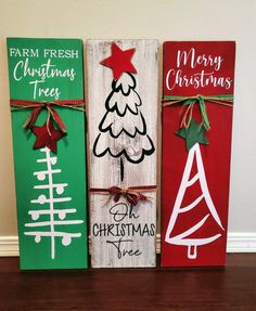 three wooden signs with christmas trees painted on them