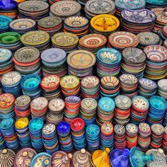 many colorful bowls are stacked on top of each other in the same color and pattern