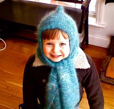 a young child wearing a blue knitted hat and scarf