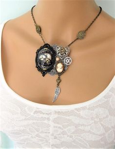 This Steampunk necklace can be interchanged to wear as a brooch too. See all the pictures. I started with a large round silver filigree piece, and added many steampunk charms, including; a large glass cabochon with steampunk gear design in black metal cabochon setting, a large antique silver metal filigree heart, caramel and ivory cameo on antique gold setting, and silver, and gold, metal steampunk gears. I added a dangle with antique gold metal heart and antique silver metal feather to the bott Silver Steampunk Jewelry For Alternative Fashion, Gothic Brooch Jewelry Gift, Steampunk Silver Jewelry For Alternative Fashion, Metal Feather, Gear Design, Filigree Heart, Steampunk Gears, Steampunk Necklace, Assemblage Jewelry