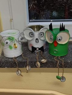 three tin can birds are standing next to each other in front of a window sill