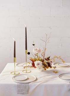 a white table topped with plates and flowers